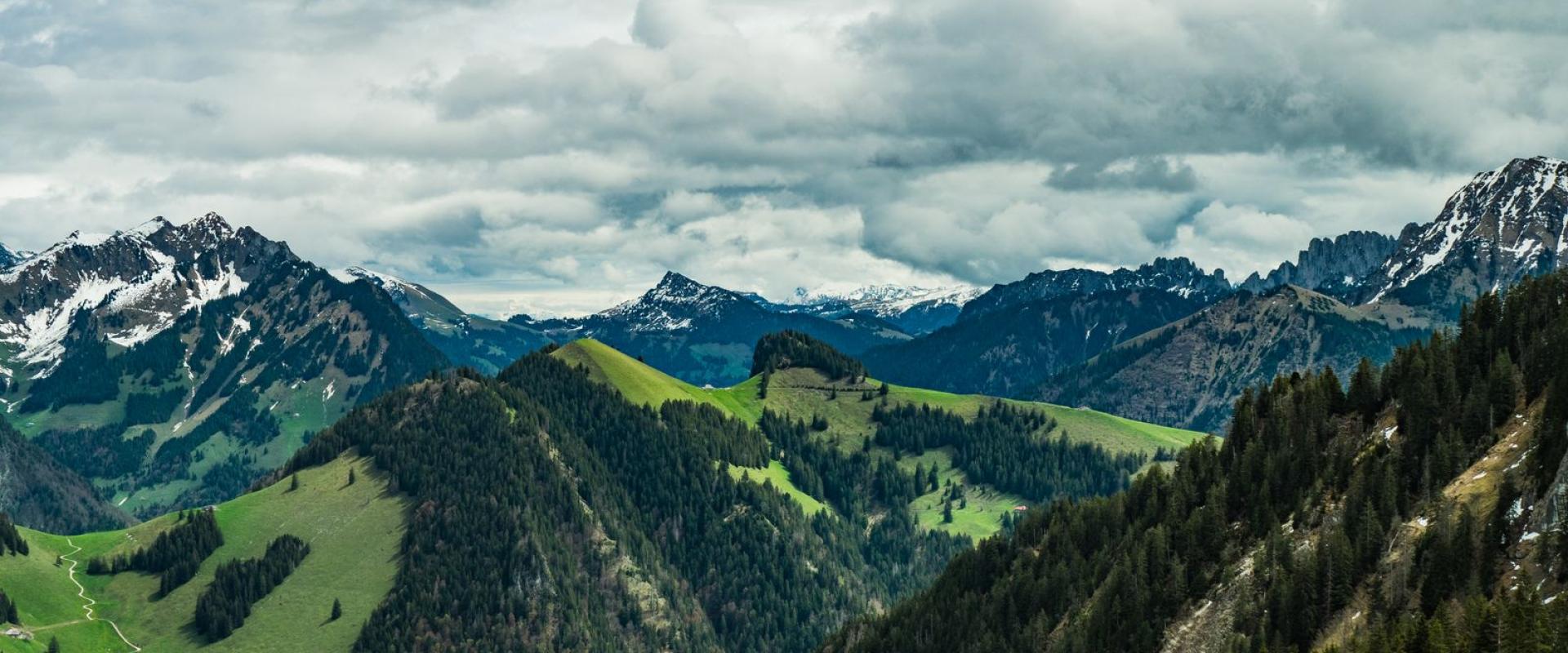 Breathtaking view of lush green valleys and majestic mountains in the Swiss Alps, perfect for nature and travel enthusiasts.