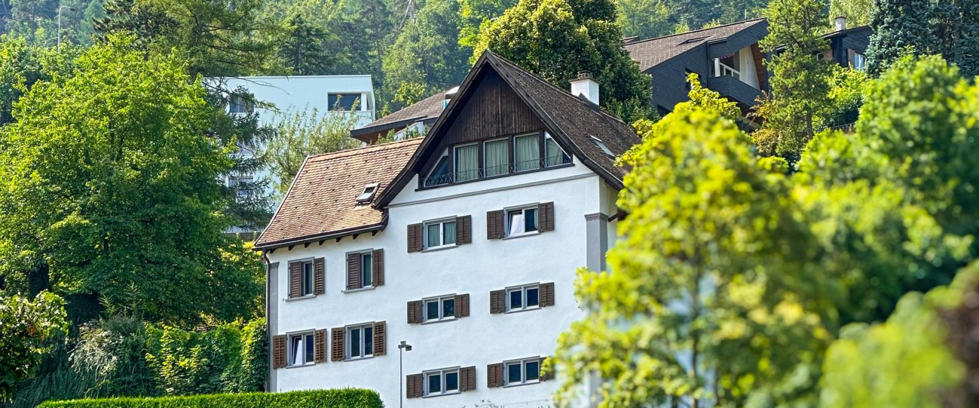 A picturesque Swiss house nestled in lush alpine surroundings. Perfect for travel inspirations.