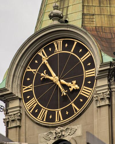 Close-up of a historic clock tower with Roman numerals in Bern, Switzerland.