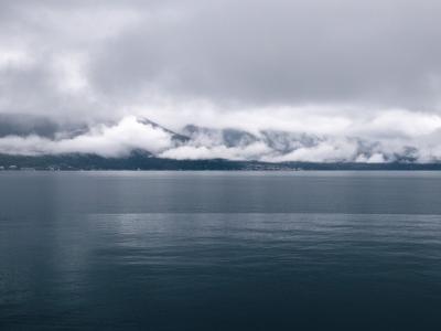 Serene view of Lake Geneva in Montreux, Switzerland with cloud-covered mountains.