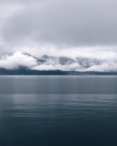 Serene view of Lake Geneva in Montreux, Switzerland with cloud-covered mountains.